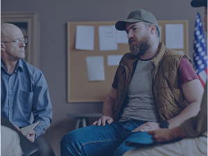 Young unhappy man with post traumatic syndrome counseling session