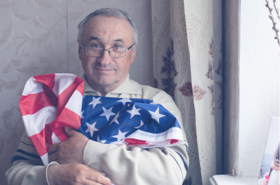 Senior man hugging American flag