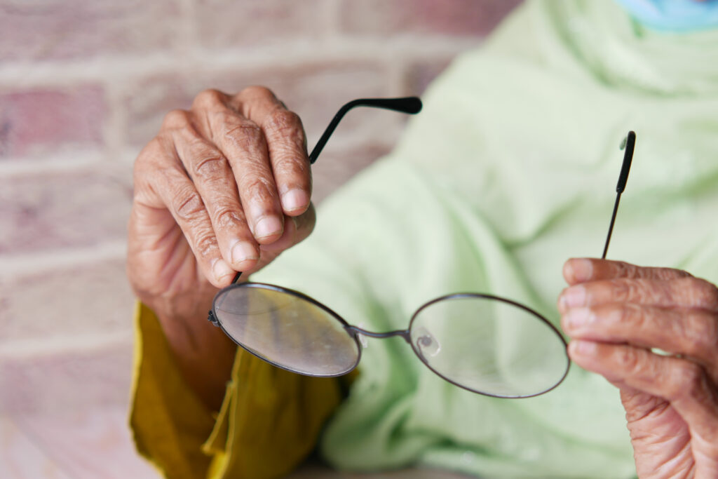 Close up of senior women hand holding old eyeglass