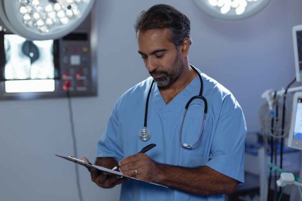 mature-male-surgeon-writing-clipboard-operation-room-hospital