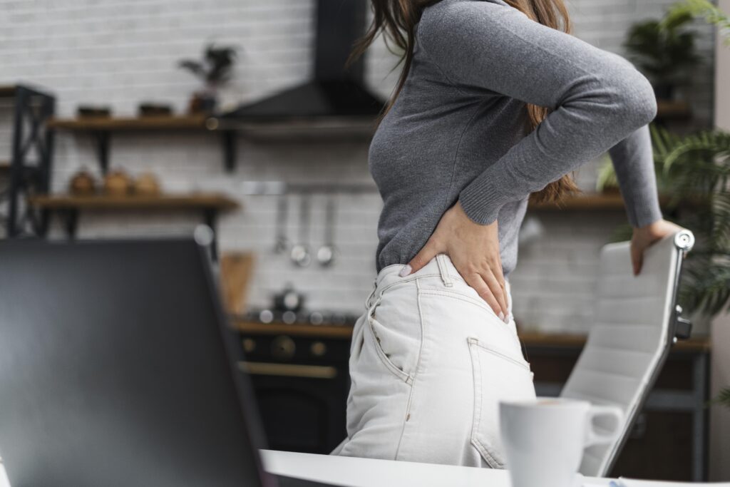 Side view woman having backache while working from home