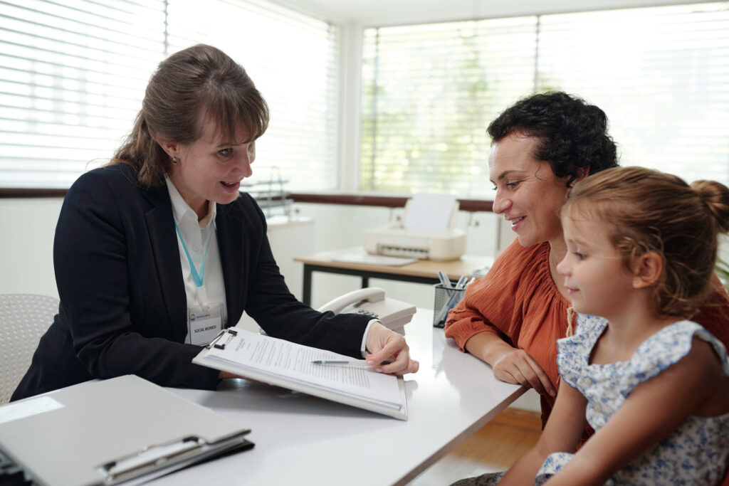 Social worker discussing agreement with family during their visit to social service