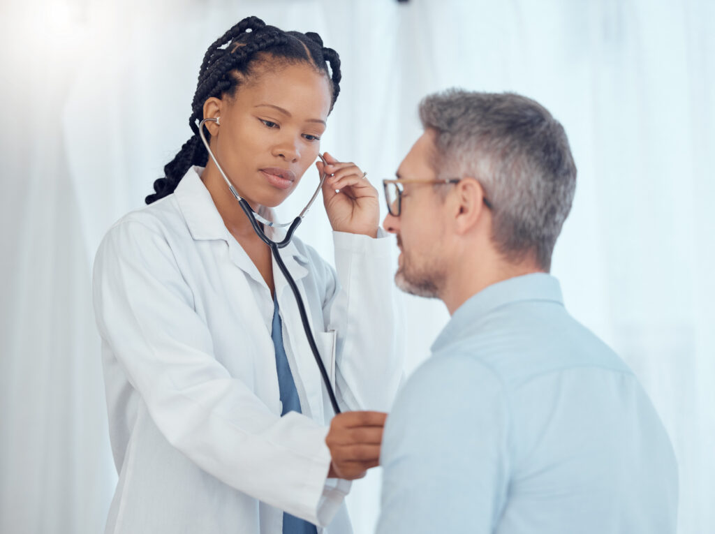 Doctor listening with stethoscope to patient heartbeat
