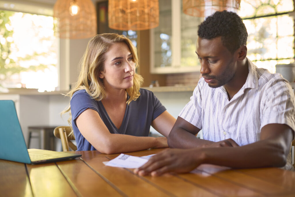 Couple with laptop at home worried about denial