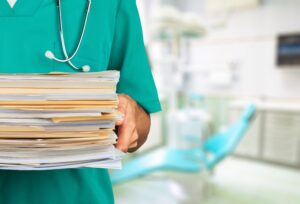 Doctor holding stack of papers on hospital background