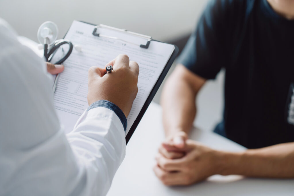 doctor holding test results and consulting patient at desk