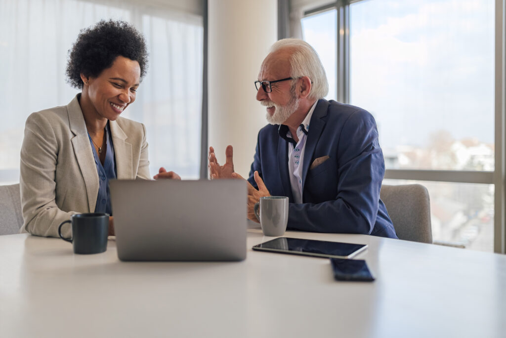 Smiling male and female professionals are planning strategy during meeting